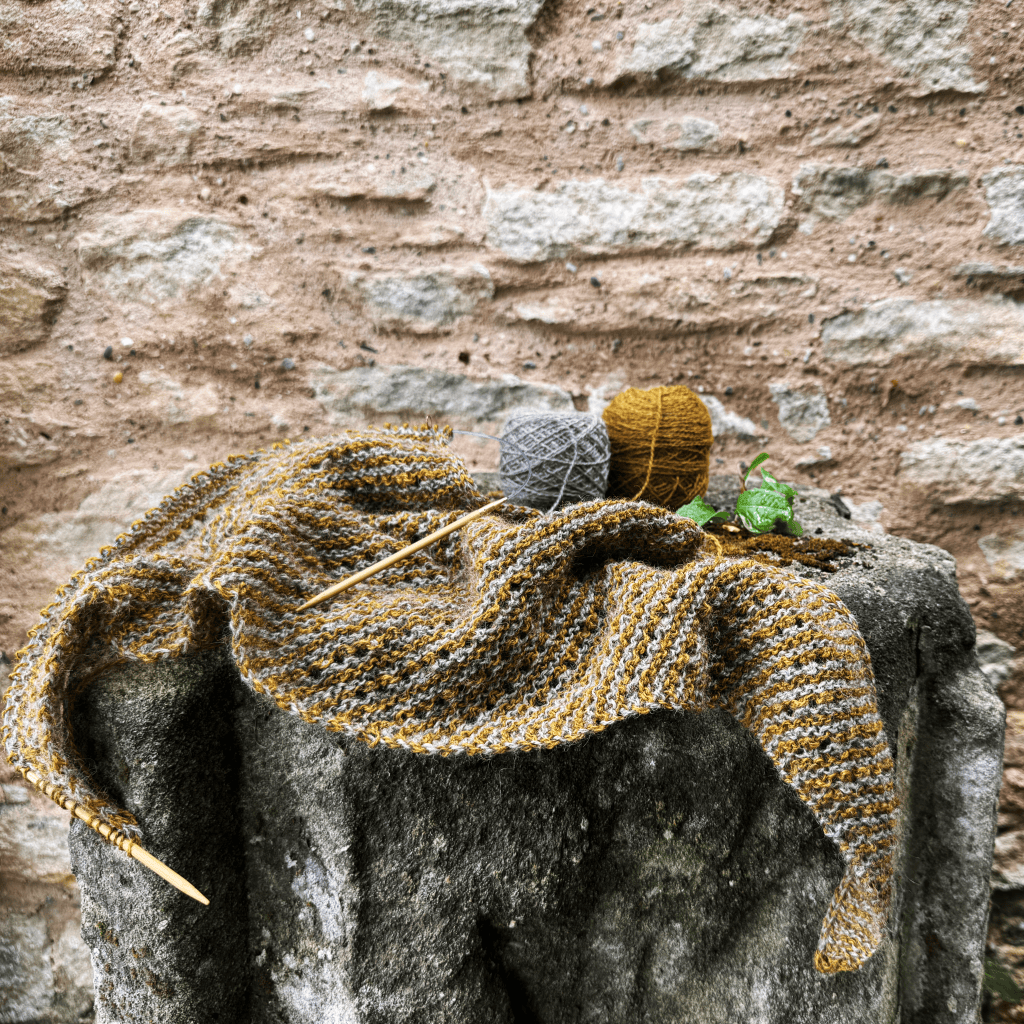 Bohemia shawl in progress on a stone wall